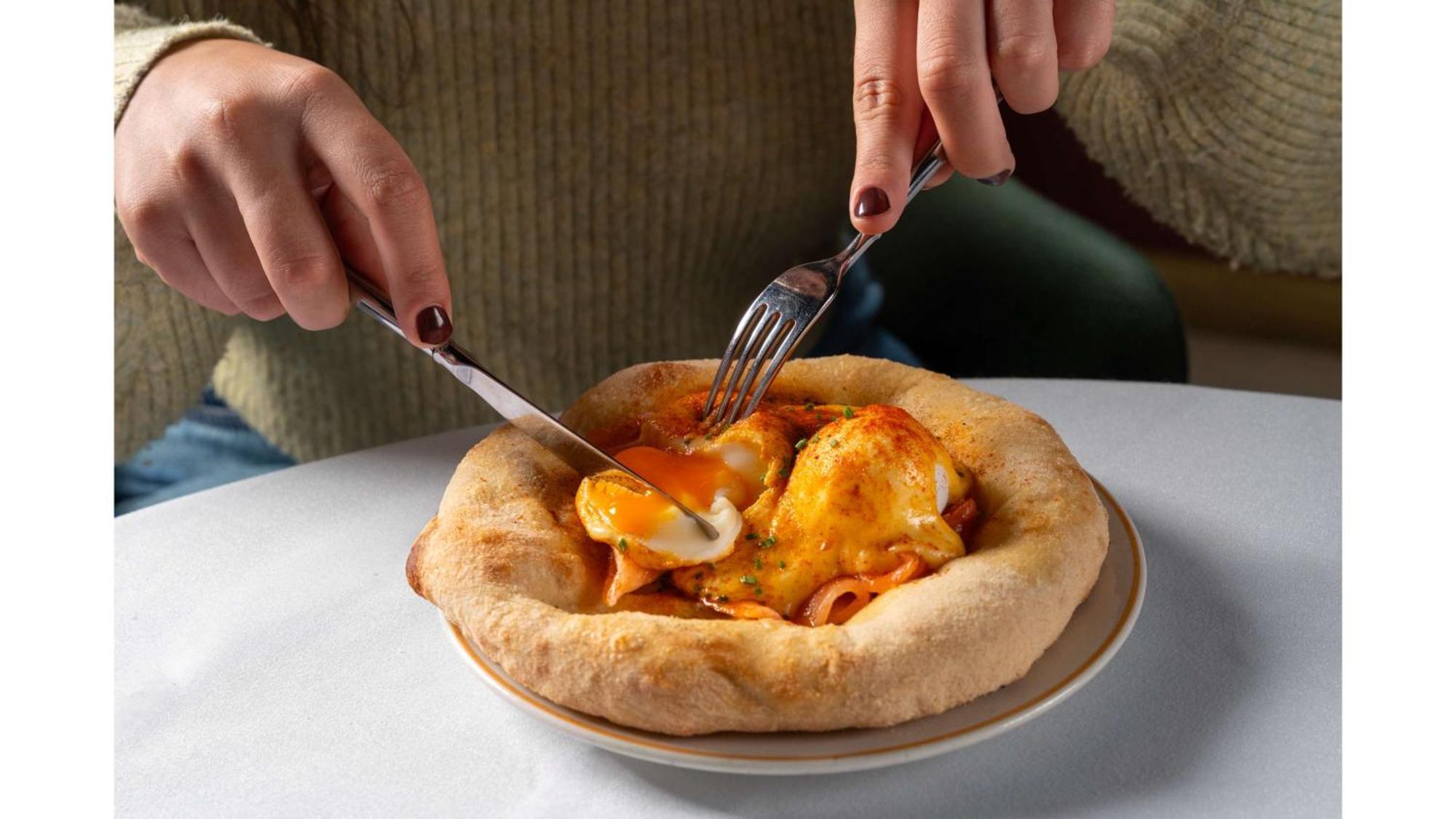 Art'Otel London Battersea Power Station, Powered By Radisson Hotels Buitenkant foto A person cutting into a pizza